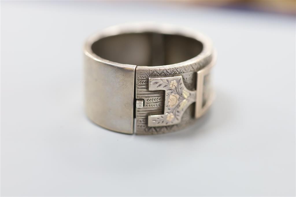 A late 19th century white and two colour yellow metal overlaid hinged bangle, gross 35.4 grams,